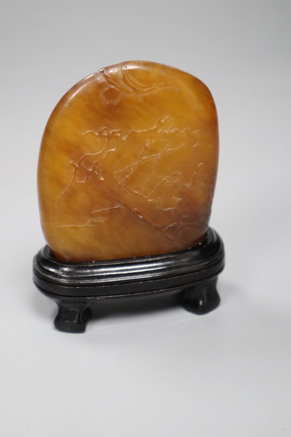 A Chinese amber coloured soapstone seal, late 19th / early 20th century, wood stand, overall height 10.5cm